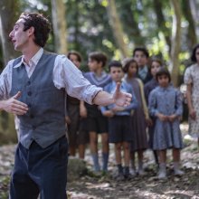 Still from the movie. The teacher dances while his students watch him. They are in a forrest.